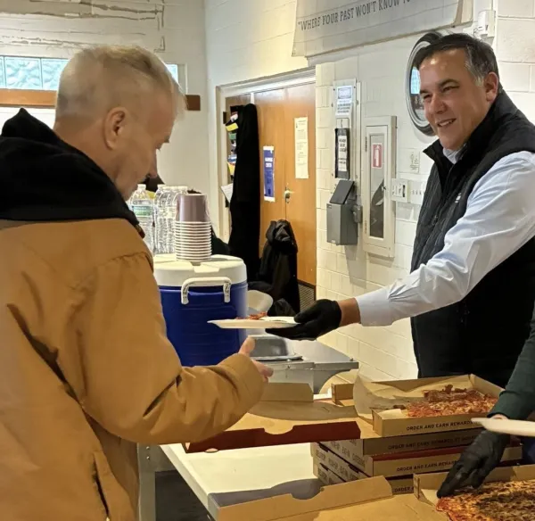 Ginther handing food to man