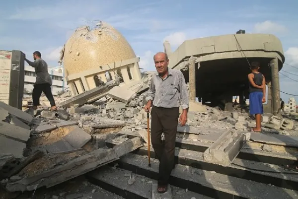 Man in front of destroyed buildings