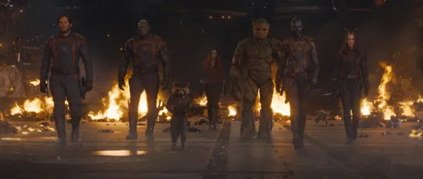 Characters walking in a line with fire in the background