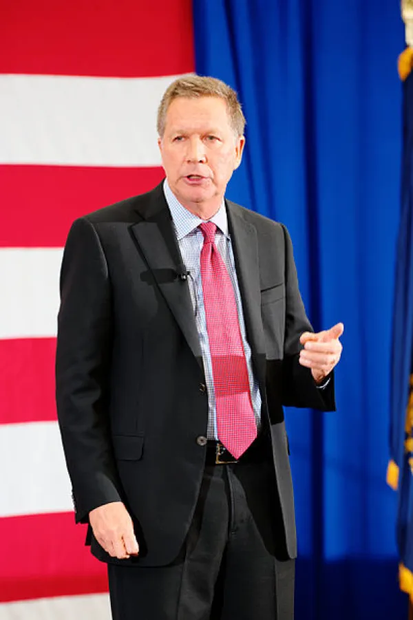 John Kasich in front of flag