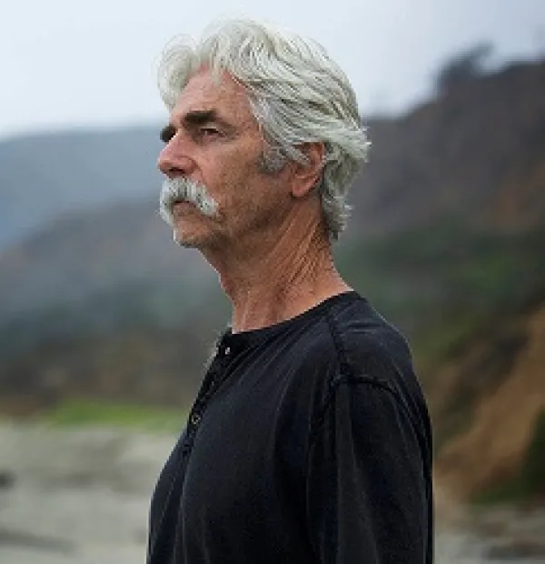 white haired man with moustache standing outside hair blowing in wind
