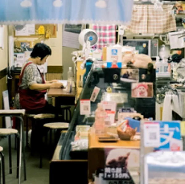 Person working at a desk in a shop filled with arts and crafts
