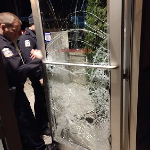 Shattered glass door and policemen
