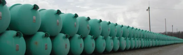 Dozens of blue green barrels lined up