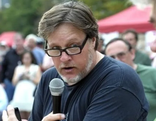 Middle aged white man holding microphone