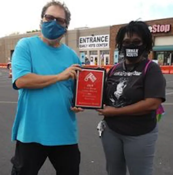 Man and woman holding a plaque