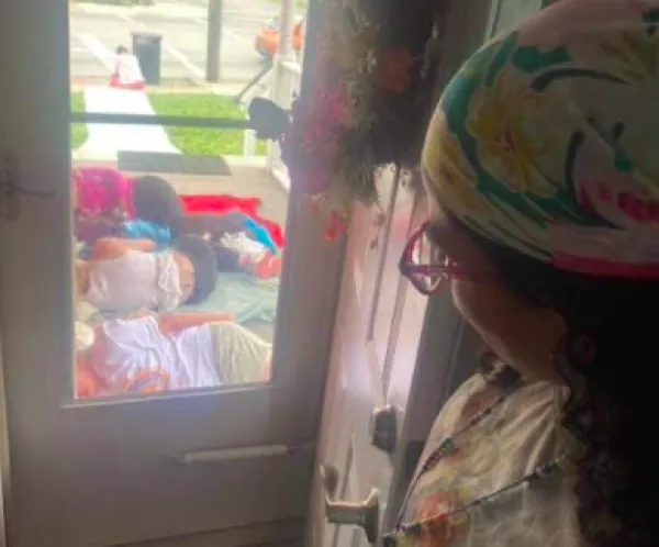 Looking out a window of women sleeping on the ground