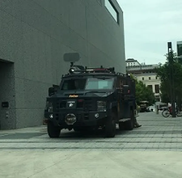 Large army-looking tank coming out of a narrow street