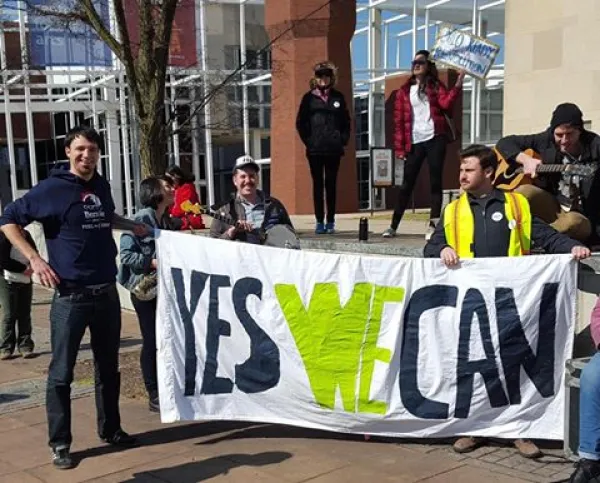 People holding Yes We Can sign