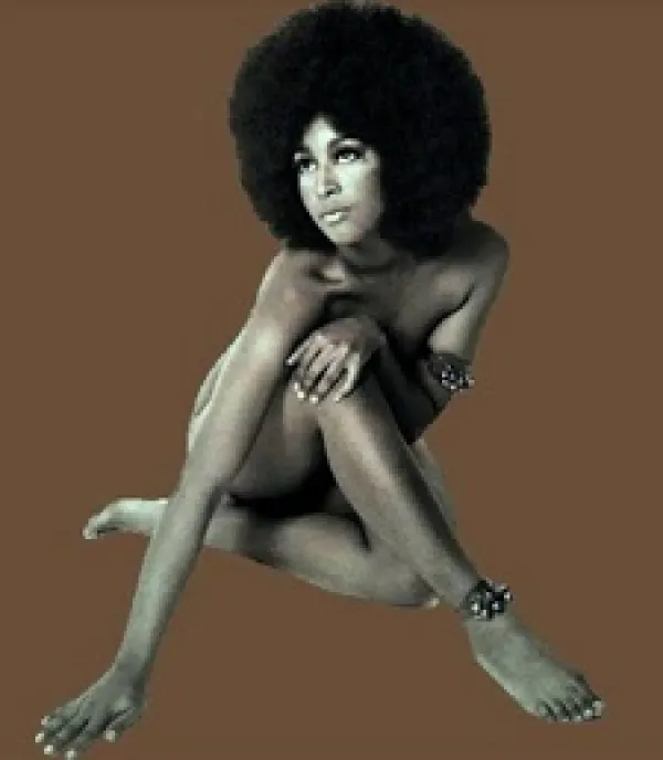 Sixties-looking photo of naked black woman covering up her private parts with arms and legs, she has a huge Afro against a brown background