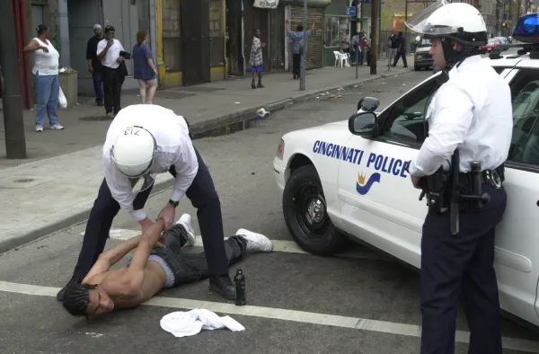 Two Cincinnati police with black man on ground in handcuffs