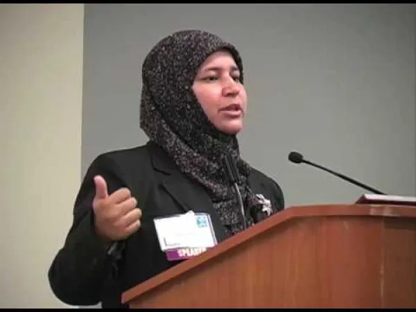 Muslim woman speaking at a mic